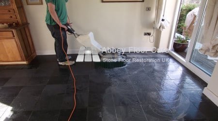 Slate floor tiles during cleaning showing visible soil and uneven colour