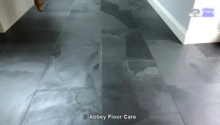 Slate floor tiles darkened by water, illustrating the temporary depth homeowners expect from a wet look finish